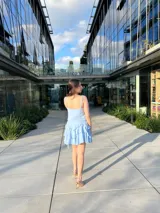 Vestido corto celeste con breteles finos, escote en V y falda con volados.