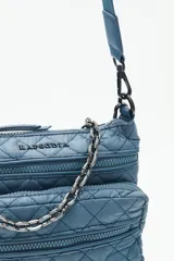 Cartera bandolera azul con diseño matelassé, cadena metálica decorativa y dos correas desmontables. Cuenta con cierre superior y múltiples bolsillos internos.