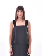 Blusa negra con breteles finos y detalle de volados.