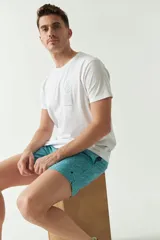 Short de baño celeste con estampado de hojas, cintura elástica con cordón ajustable, dos bolsillos laterales y uno trasero.