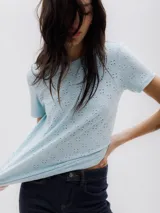 Camiseta celeste de manga corta con tejido calado y cuello redondo.