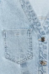 Vestido corto de denim azul, con cuello solapa, escote en V, manga corta, bolsillos delanteros y cierre frontal con botones metálicos.