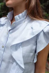 Vestido corto rojo de lino con cuello mao fruncido, volados en los hombros, caída recta y botones al frente.