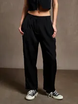 Pantalón negro de vestir con pinzas, corte holgado y tiro alto.