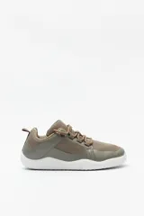 Zapatillas marrones inspiradas en el calzado barefoot, con suela fina, plana y flexible, sin tacos ni soporte rígido. De textil transpirable, cordones a tono y suela blanca.