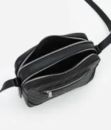Bolso bandolera pequeño color marrón con textura geométrica en relieve. Tiene correa larga regulable, cierre de cremallera y separadores internos.