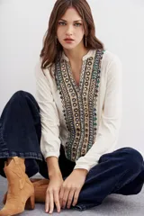 Camisa color crudo con bordados multicolores y espejos en el frente, escote en V y mangas largas.