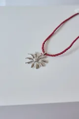 Collar con dije de acero quirúrgico hipoalergénico en forma de margarita plateada y tiento sailor color borgoña.