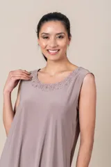 Conjunto de vestido corto color beige con bordado dorado en el escote y túnica de tul combinada.