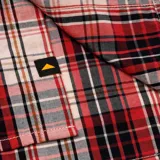 Camisa de manga larga a cuadros rojos, negros y beige, con cuello clásico, cierre con botones y bolsillo en el pecho con logo de la marca.