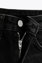 Bermuda de jean negro, tiro alto, corte mom fit, con trabillas y cinco bolsillos.