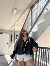 Camisa negra de mangas 3/4 con estampado abstracto en blanco.