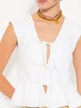 Top blanco de lycra doble, con mangas japonesas y escote en V con lazos de poplin. Tiene doble volado caracol en el ruedo.