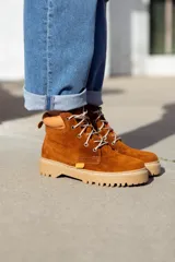 Bota acordonada de cuero color marrón óxido con suela de goma color beige.