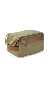 Neceser verde de tela canvas con detalles en cuero marrón. Tiene doble cierre superior, bolsillos internos con cierre y abiertos, bolsillo frontal con solapa y asa lateral.