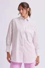 Camisa oversize blanca con rayas verticales rosas, de manga larga con puños abotonados, cuello clásico y bolsillo de parche en el pecho.