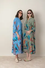 Vestido largo de lino color verde militar con estampado de hojas en tonos azul, naranja y marrón. Tiene cuello mao con botones, mangas tres cuartos y un bolsillo en el pecho.