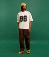 Remera de corte boxy color crema con estampa del número 96 en el frente y detalles en negro en cuello y mangas.