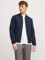 Campera bomber azul marino de corte clásico, con cuello de béisbol, cierre frontal con cremallera, bolsillos laterales con cremallera y bolsillo en la manga.