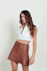 Top corto blanco con escote halter y tiras finas en la espalda.