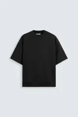 Sudadera negra de corte holgado confeccionada en tejido interlock de algodón con elasticidad. Tiene cuello redondo, mangas cortas y bajo con terminación en rib.