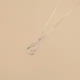 Conjunto de collar con dije de plata 925. El dije consiste en dos formas abstractas superpuestas con forma de gota alargada. La cadena es tipo caja, fina y plateada.
