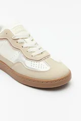 Zapatillas urbanas de gamuza color beige, blanco y verde, con recortes en símil cuero y suela de goma marrón de 2,5 cm de altura.