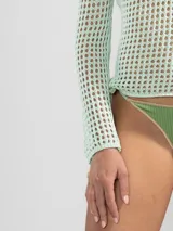 Sweater de tejido calado negro, con manga larga y cuello bote.