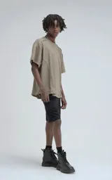 Remera de manga corta y cuello redondo, color verde militar, confeccionada en algodón premium con textura de tejido a rombos. Presenta un calce regular con recortes deshilachados en los hombros.