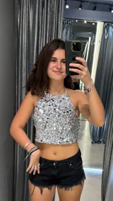 Top plateado con lentejuelas, escote halter y espalda descubierta.