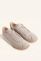Zapatillas deportivas de cuero color borgoña con detalles en gamuza al tono, cordones finos y suela de goma blanca.
