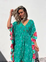 Túnica corta verde con estampado de flores rojas y detalles bordados. Mangas anchas con terminación en volados con estampado floral en tonos rosa y celeste.