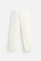 Pantalón chino color crema de corte recto, confeccionado en tejido de algodón con elasticidad. Cuenta con bolsillos frontales y traseros de plastrón con botón. Cierre frontal con cremallera y botón.