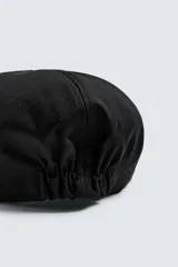 Boina negra con visera confeccionada en tejido con algodón y lino.