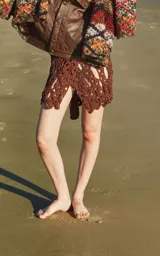 Minifalda tejida a mano en algodón color marrón, con textura de zig zag y corte irregular.