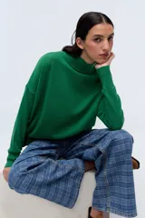 Polera de punto color verde, con cuello alto y calce holgado.