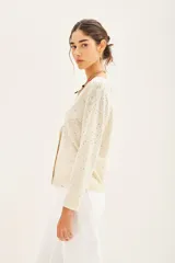Cardigan color crema de tejido de punto con escote en V y aplicación de tachas termofijadas.