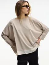 Sweater beige de viscosa y lino, de corte amplio con mangas largas ajustadas y detalle de superposición en el bajo.