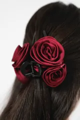 Broche para el pelo tipo pinza, color negro, con aplique de tres rosas de tela color burdeos.