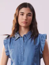 Blusa celeste de lyocell con cuello camisero, abertura con botones y volados en las sisas.