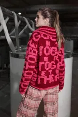 Cárdigan tejido de lana color borgoña con bordado de letras rosas que forman la frase "Good To Be Together". Tiene cuello redondo, cierre frontal con cremallera y calce holgado.