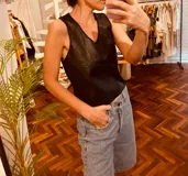 Top negro con frente de cuero, contornos bordados a mano y espalda tejida en hilado de algodón.