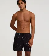 Bermuda de microfibra negra, tipo playera, con cintura elástica ajustable mediante cordón y bolsillos laterales. Presenta una estampa repetida de pequeñas calaveras y palmeras en color blanco.