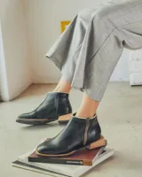 Bota corta de cuero negro con cierre lateral y suela de madera.