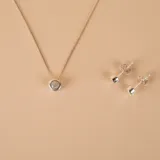 Conjunto de collar y caravanas en plata 925 con circonias. El collar tiene una cadena de 45cm y un dije de 5mm de diámetro.