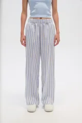 Pantalón de algodón a rayas verticales celestes y blancas, de corte holgado y tiro alto.