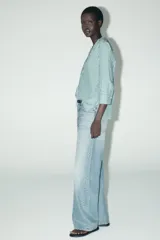 Camisa de mujer con cuello solapa y manga tres cuartos con estampado a rayas verticales verdes y blancas. Cierre frontal con botones ocultos.