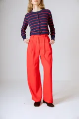 Pantalón negro de corte ancho y tiro alto, con pinzas en la cintura y bolsillos laterales.