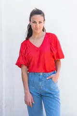 Blusa azul de escote pico y manga corta con volados en la parte delantera.