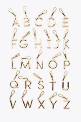 Dije dorado en forma de la letra A, con mosquetón para colgar en carteras o pulseras.